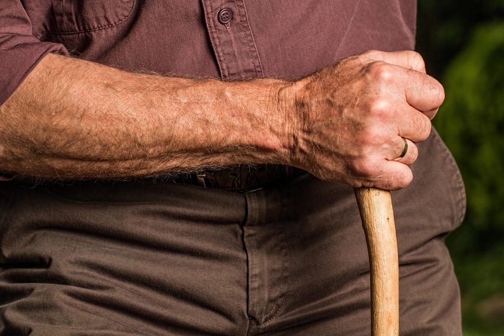 Préparer sereinement sa retraite Main d’un senior tenant une canne, représentant la préparation à la retraite
