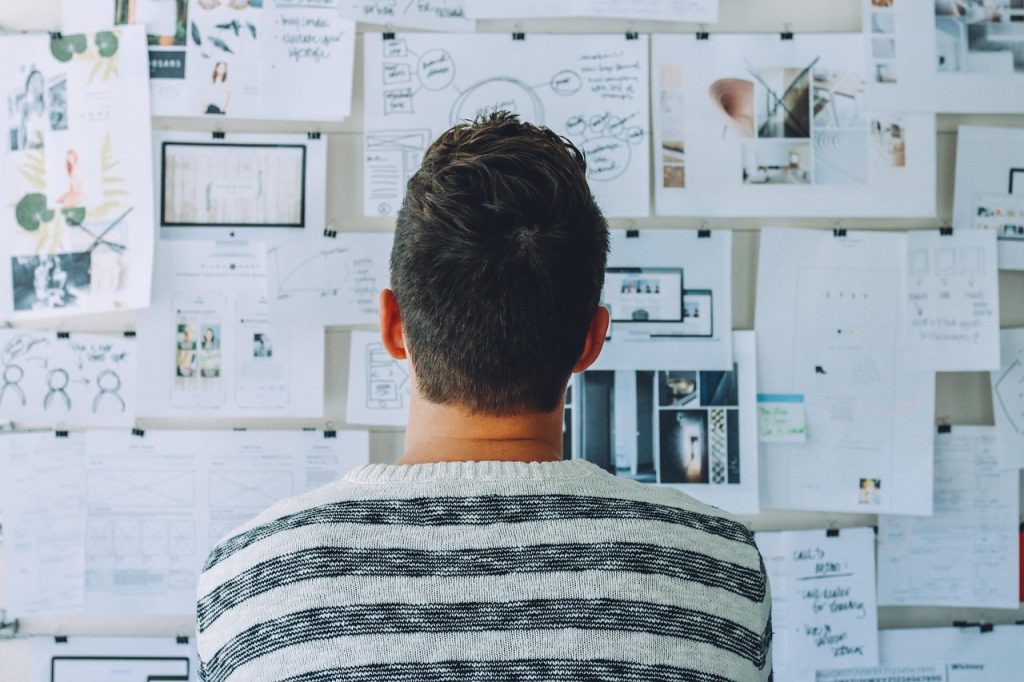 Stratégie de financement personnalisée Homme consultant des plans financiers et de projets sur un mur d’inspiration